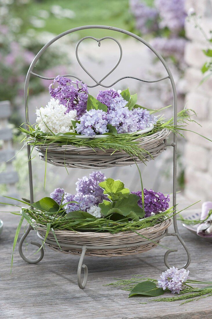 Etagere with baskets and heart motifs, filled with syringa flowers