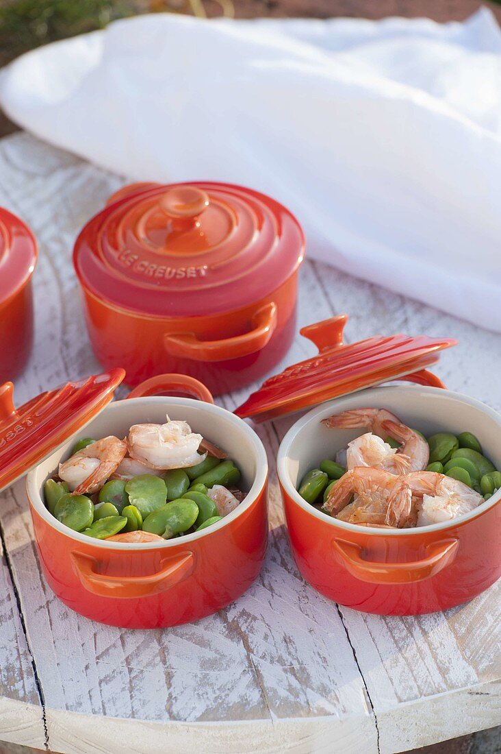 Broad beans with prawns and fennel in red oven moulds