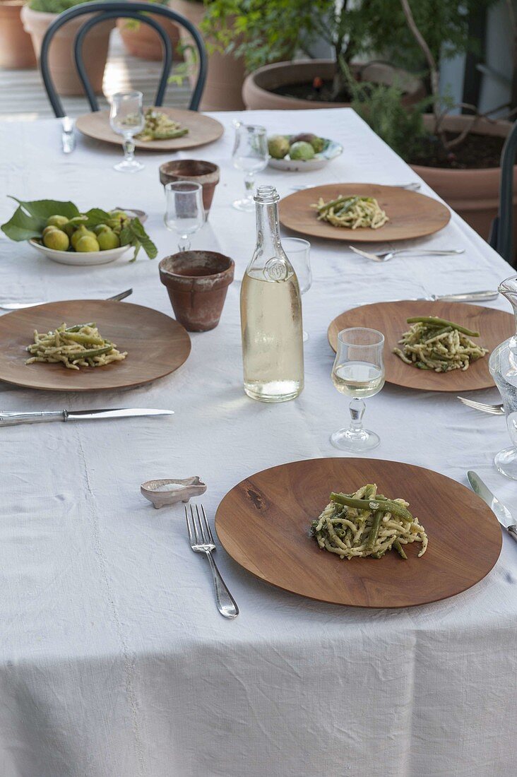 Set table on terrace, pasta with beans as starter