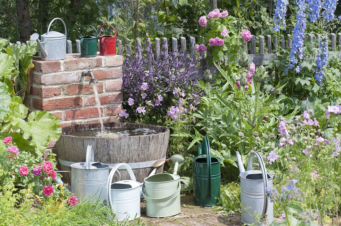 Wasserfass und Wasserhahn für die Bewässerung im Bauerngarten