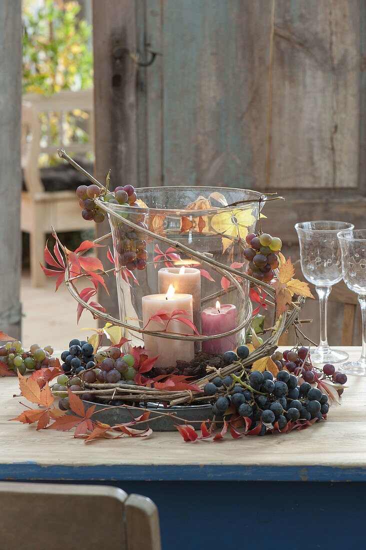 Large glass with candles as a lantern, decorated with grapes