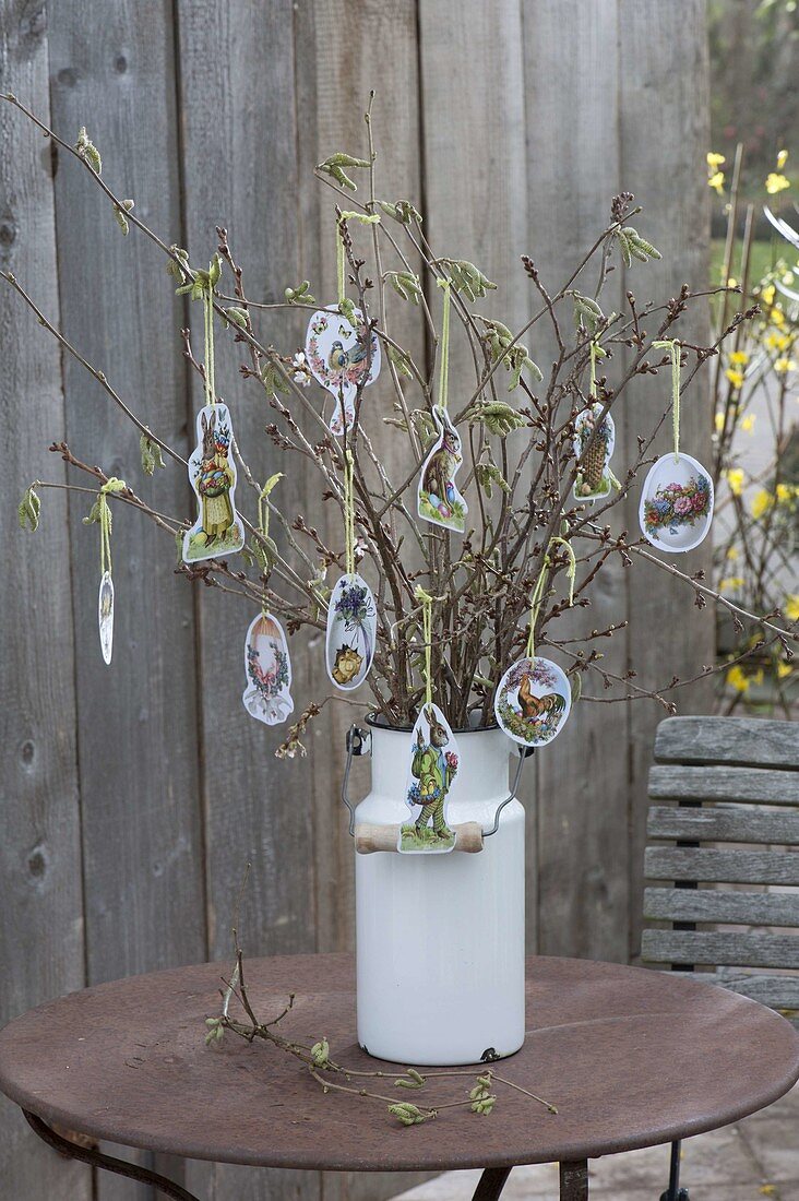 Easter bouquet of branches in old milk can, decorated with Easter wafers