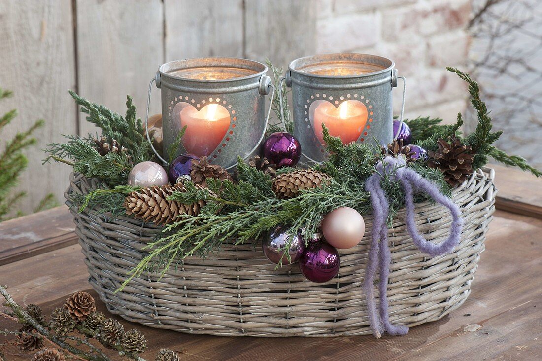 Heart lanterns in basket with branches of Juniperus