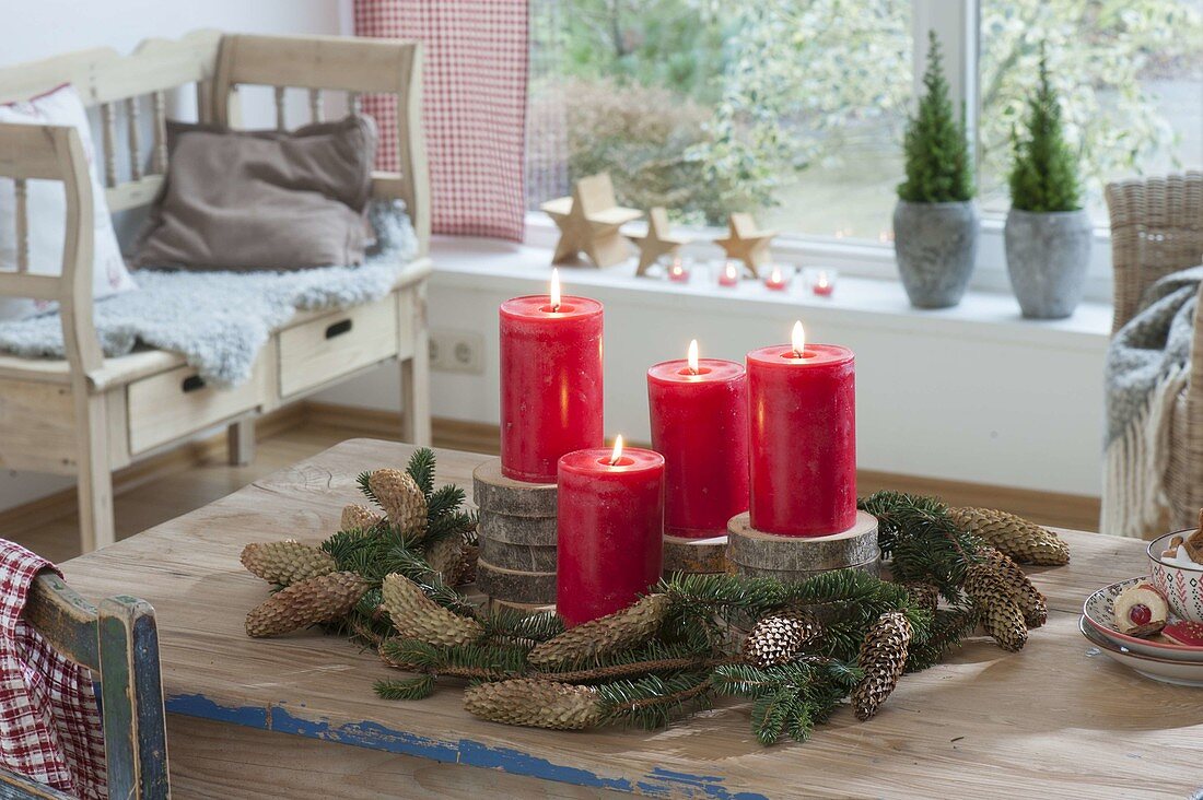 Simple Advent decoration with red candles on wooden discs