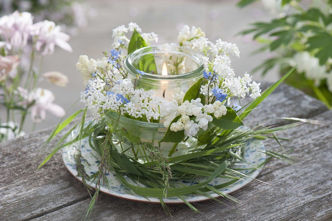 Einmachgläser ineinandergestellt als Windlicht mit Syringa (Flieder)