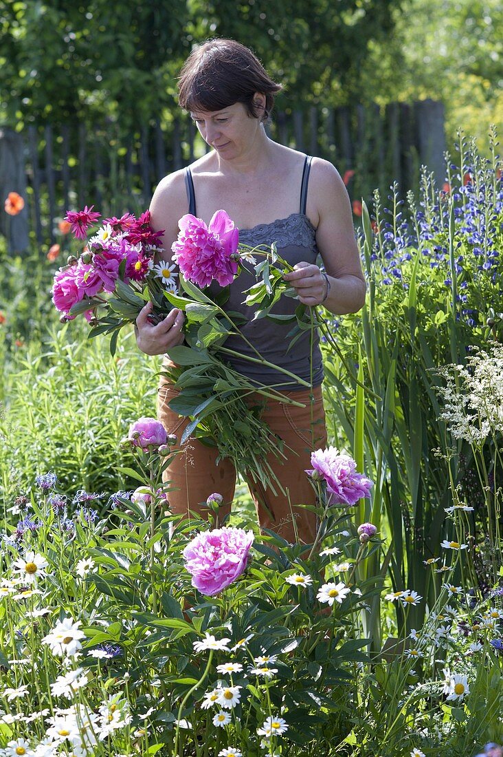 Frau schneidet Blumen für Blumenstrauss