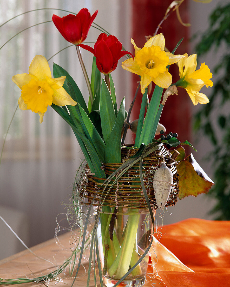 Daffodils and tulips in a frame of willow branches