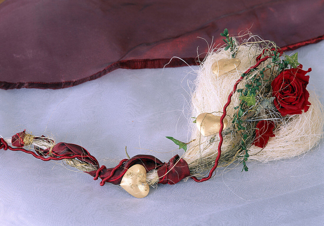 Herz aus Holzwolle, getrockneten Rosenblüten, Bänder und Efeuzweig