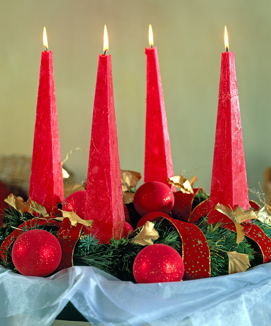Advent wreath with red pyramid candles and red baubles