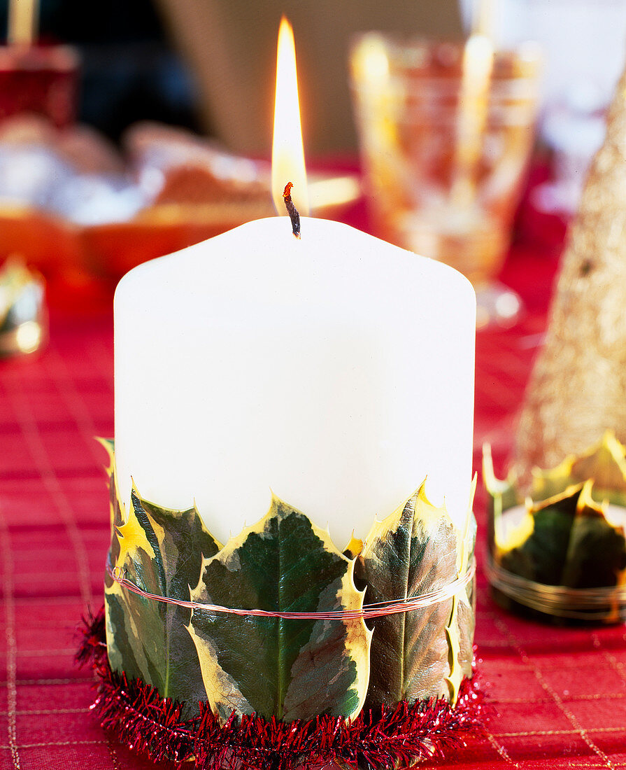 Candle decorated with Ilex leaves (holly)