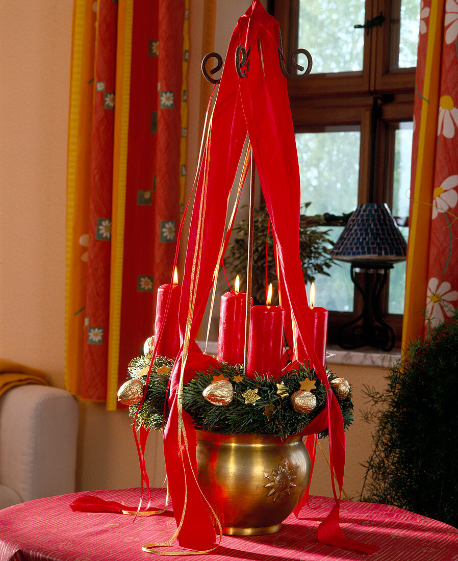 Hängender Adventskranz mit Bändern und roten Kerzen