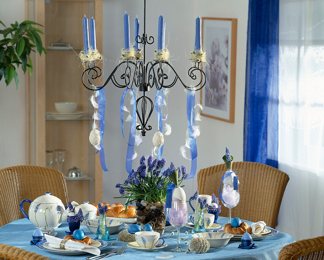 Easter table decoration with grape hyacinths and candlestick
