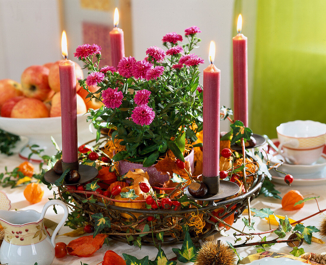 Tischdekoration: Eisenkorb herbstlich geschmückt mit Blättern, Zierkürbissen