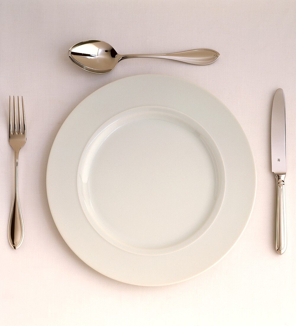 Ein weißer Teller mit Besteck