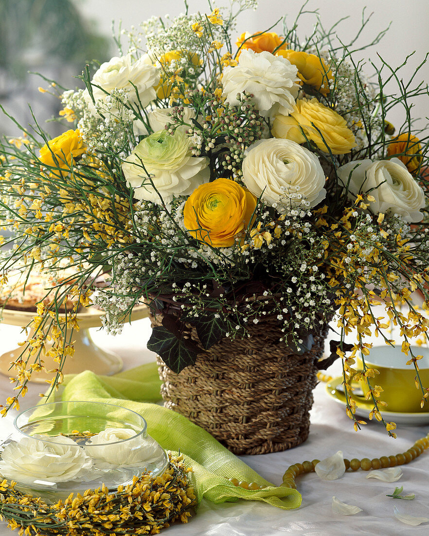 Bouquet of ranunculus, blueberry branches, yellow broom