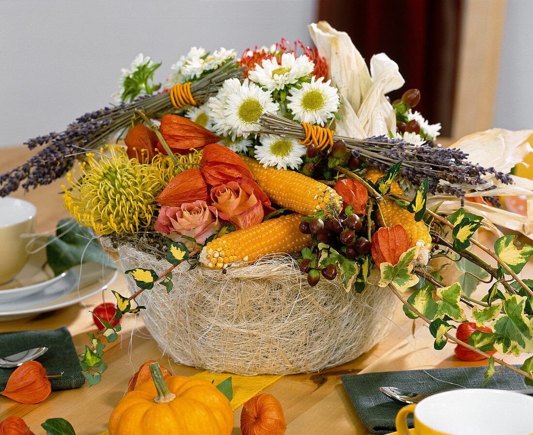 Basket of roses, corncobs, autumn chrysanthemums and lantern flowers