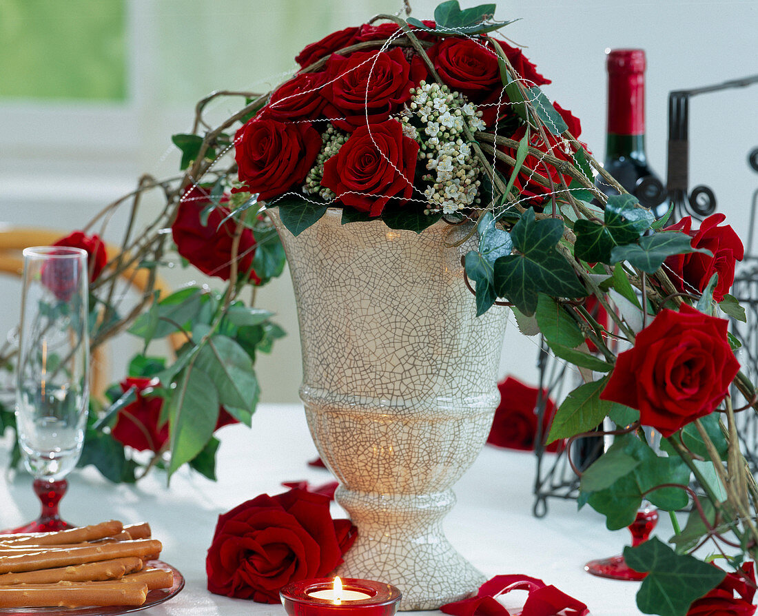 Vase mit Gesteck als Tischdekoration aus roten Rosen
