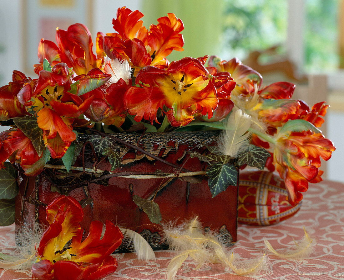 Jardiniere with bouquet of tulips, Hedera (ivy), feathers