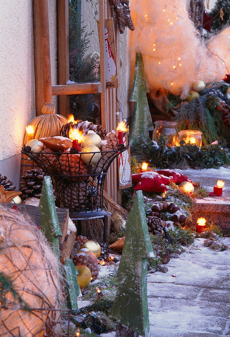 Weihnachtliche Dekoration am Hauseingang, Zapfen, Kugeln, Holzbäume, Kerzen