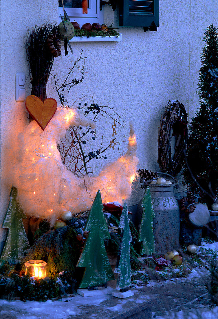 Christmas decoration at the entrance of the house; wooden trees, moon as light object.