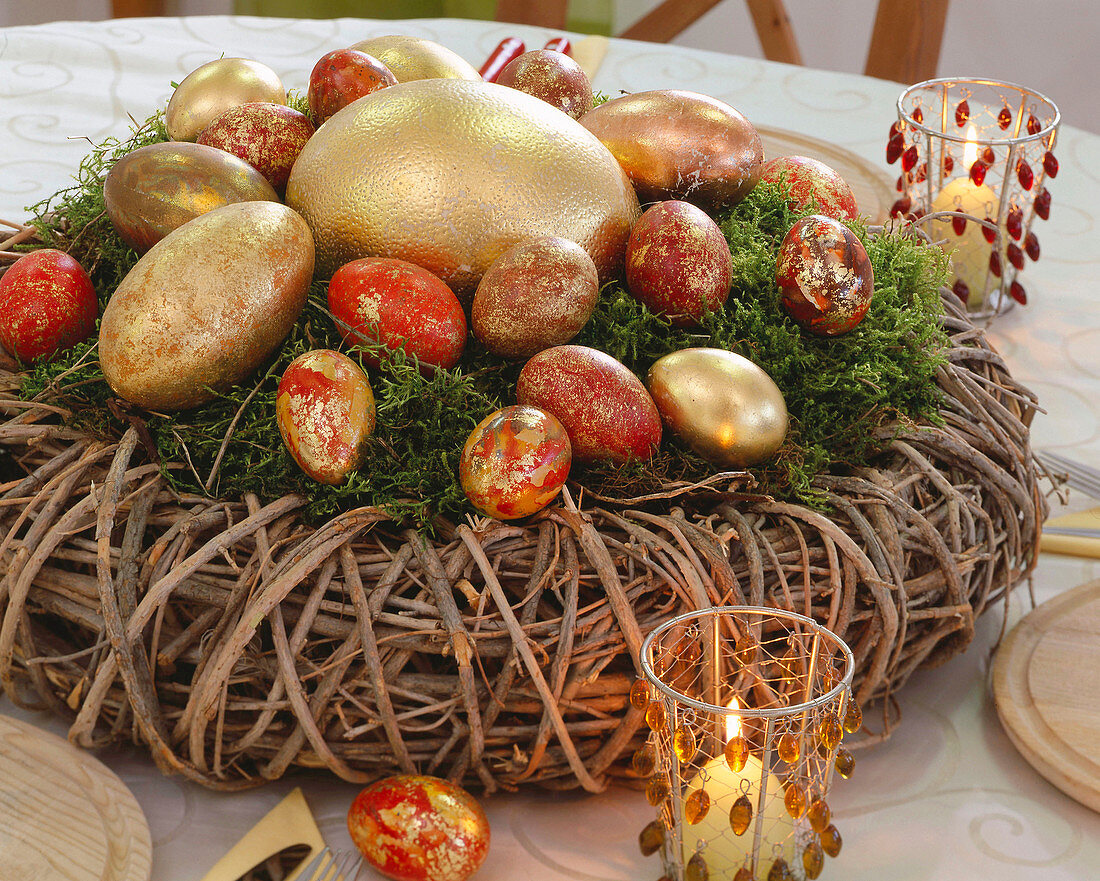 Wreath made of willow rods filled with moss and with marbled eggs made of gold leaf
