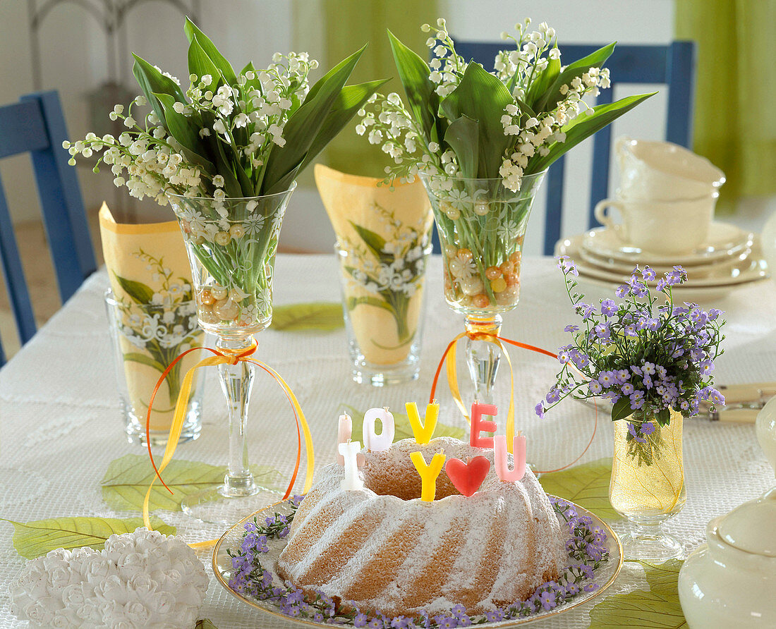 Convallaria (Lily of the Valley) in wine glasses with cupcakes, candles, from letters