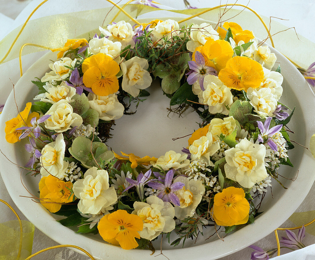 Plate wreath of flowers of violets, daffodils, spring star and spring rose