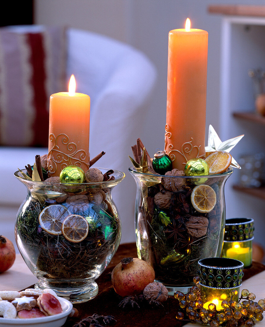 Glasses filled with Citrus (orange slices), Juglans (walnuts), moss, cinnamon stick