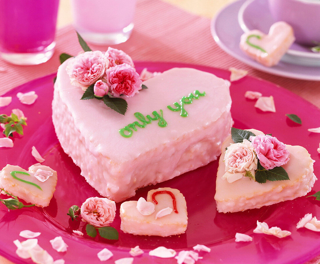 Heart-shaped cakes with pink icing, Rosa chinensis (mini roses)
