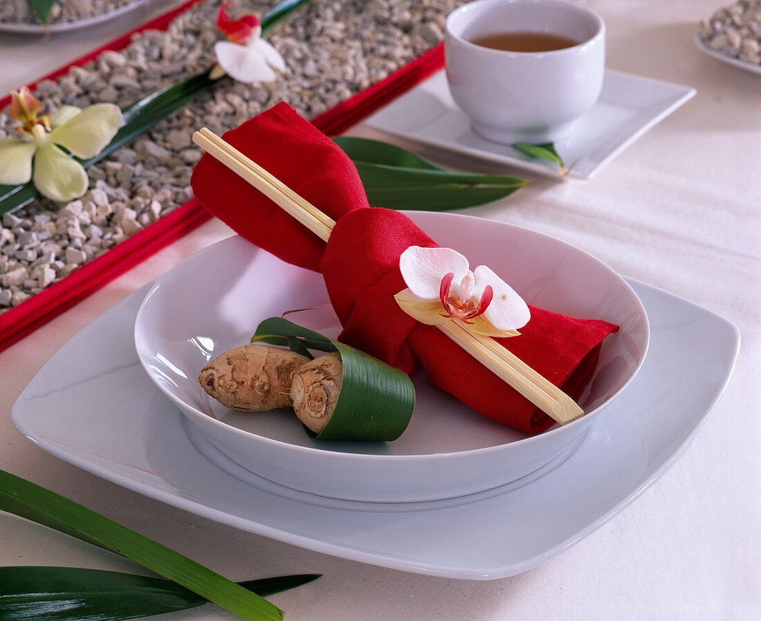 Asian plate decoration: red napkin with chopsticks and phalaenopsis