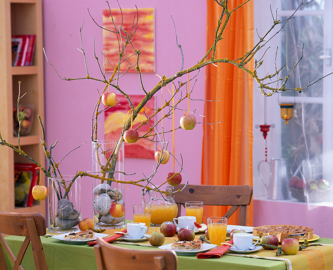 Malus (apples) hung on twigs and hollowed out as tea light holders, twigs