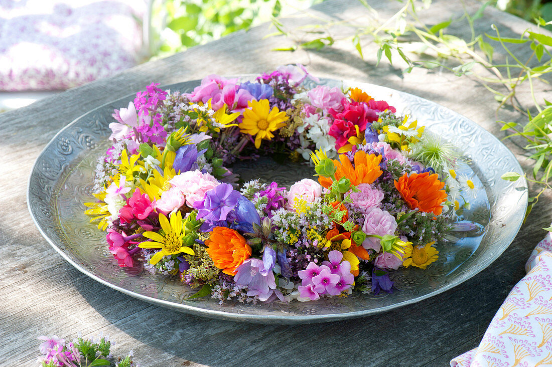 Tying colorful summer flowers wreath