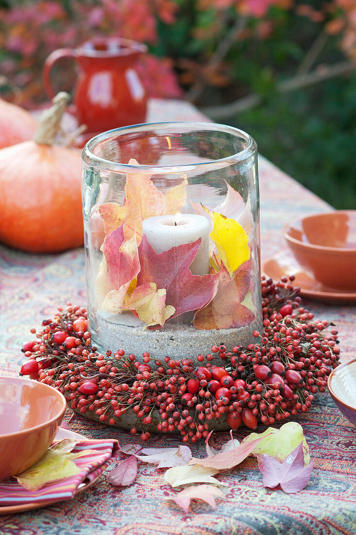 Lantern with colorful leaves in roses (rosehip) wreath