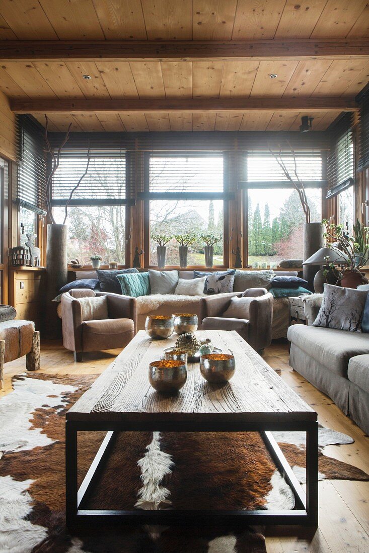 Lounge in gemütlicher Dachta mit Tierfellteppich und Gartenblick