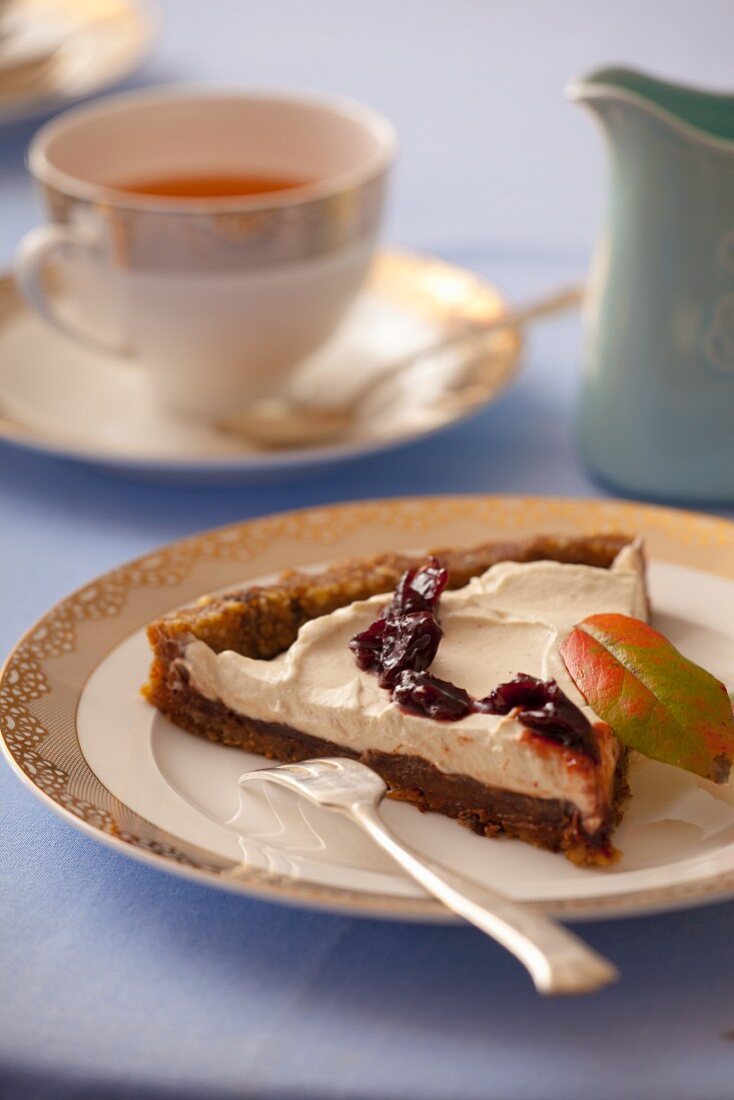 Ein Stück Tarte mit getrockneten Datteln, Feigen, Walnüssen, Schokolade, Schlagsahne und Marmelade