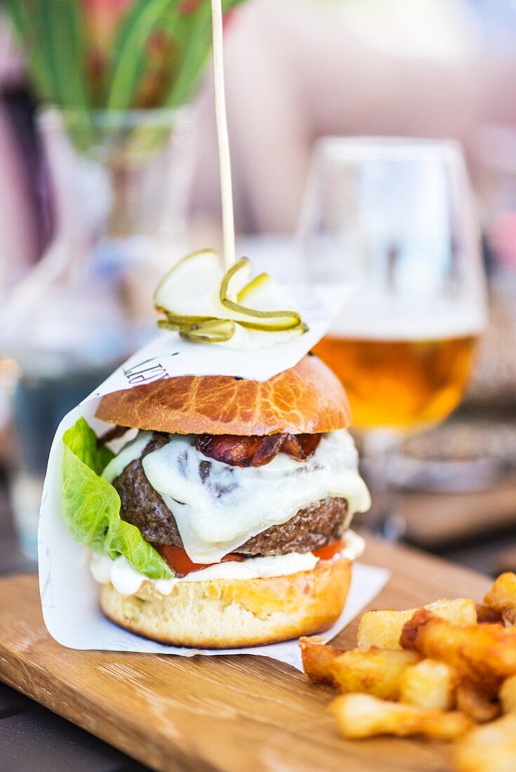 Cheeseburger und Pommes auf Holzbrett