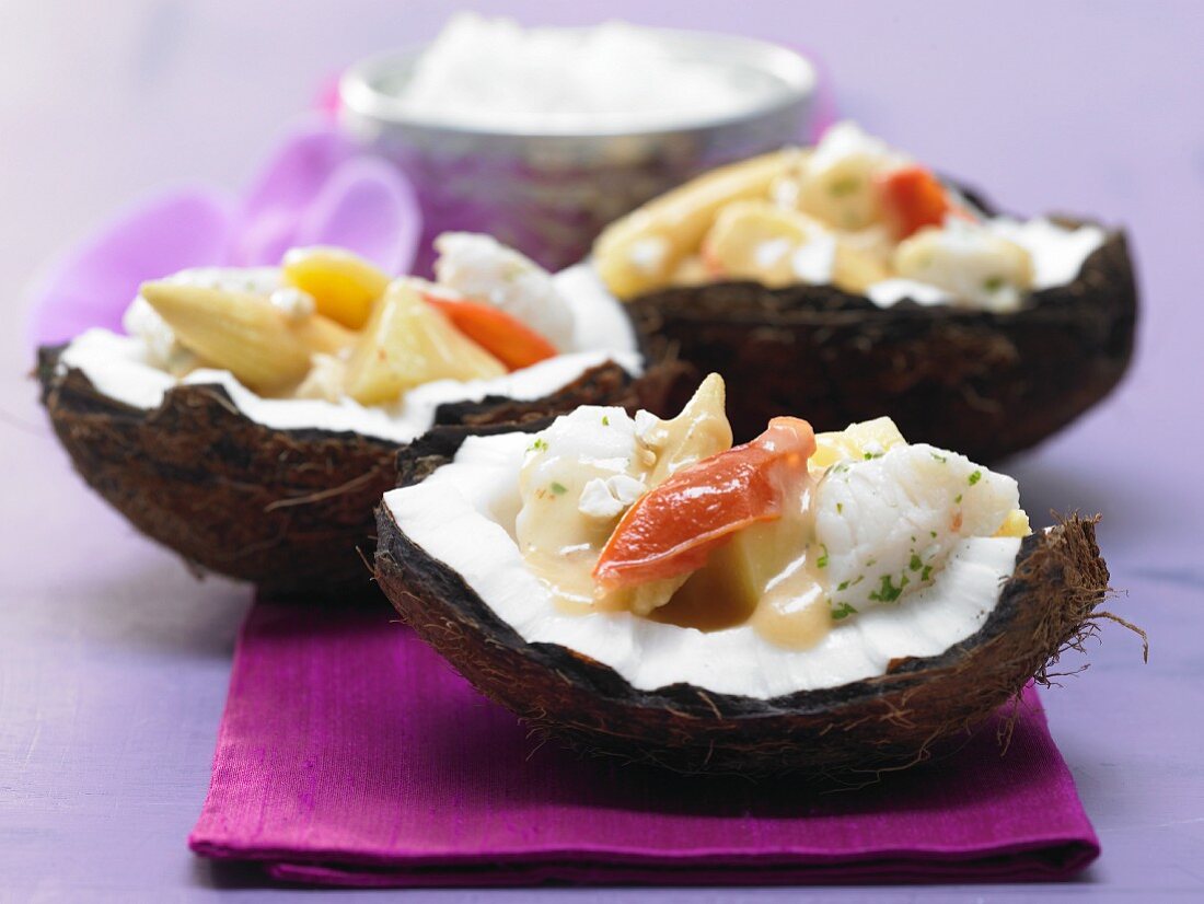 Fischcurry mit Tomate und Mais in einer Kokosnuss serviert