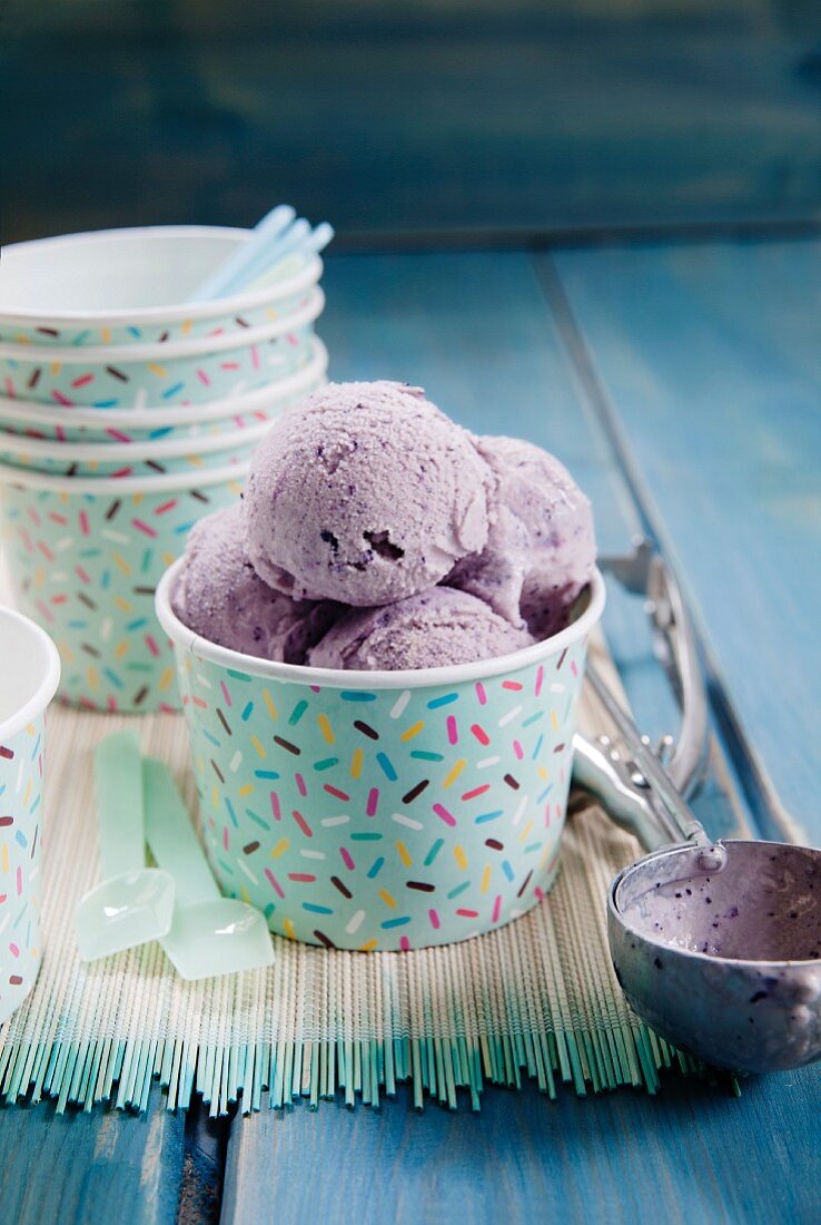 Scoops of blueberry ice cream in a cardboard tub