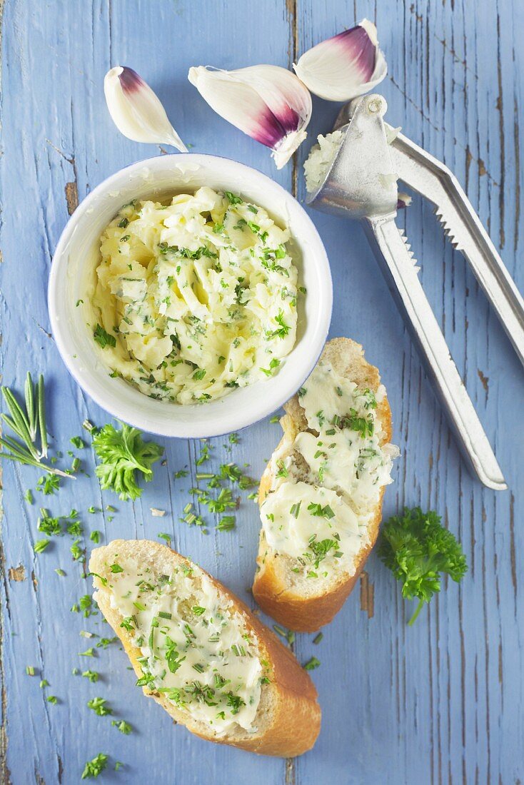 Garlic bread and herb butter on a blue wooden background