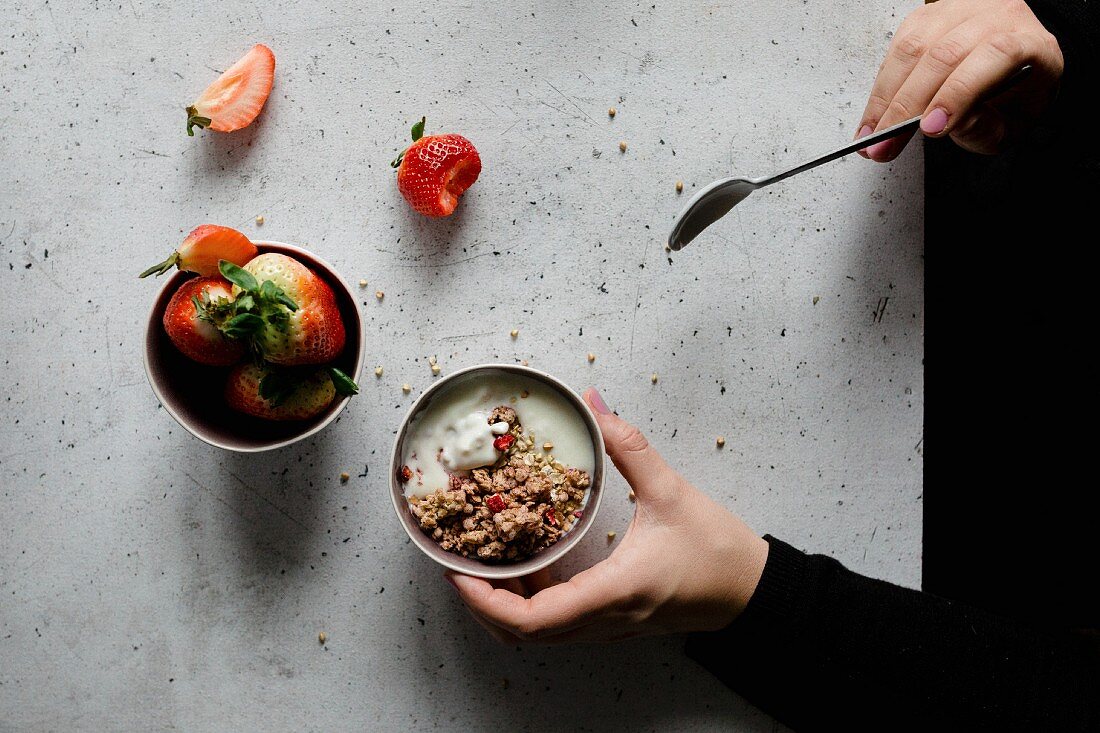 Homemade granola and a bowl of strawberries