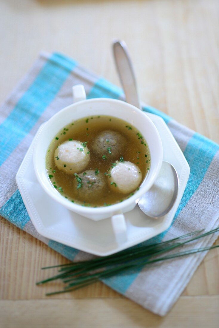 Clear broth with dumplings and chives