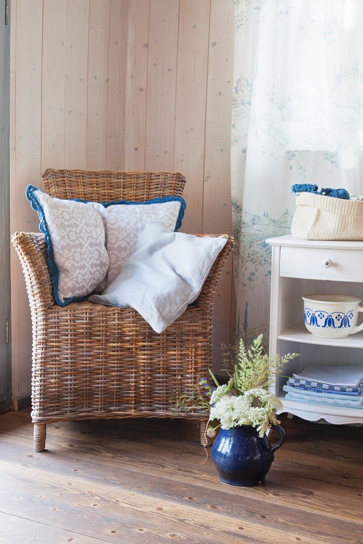 Cushions with crocheted trim on wicker chair in rustic living room