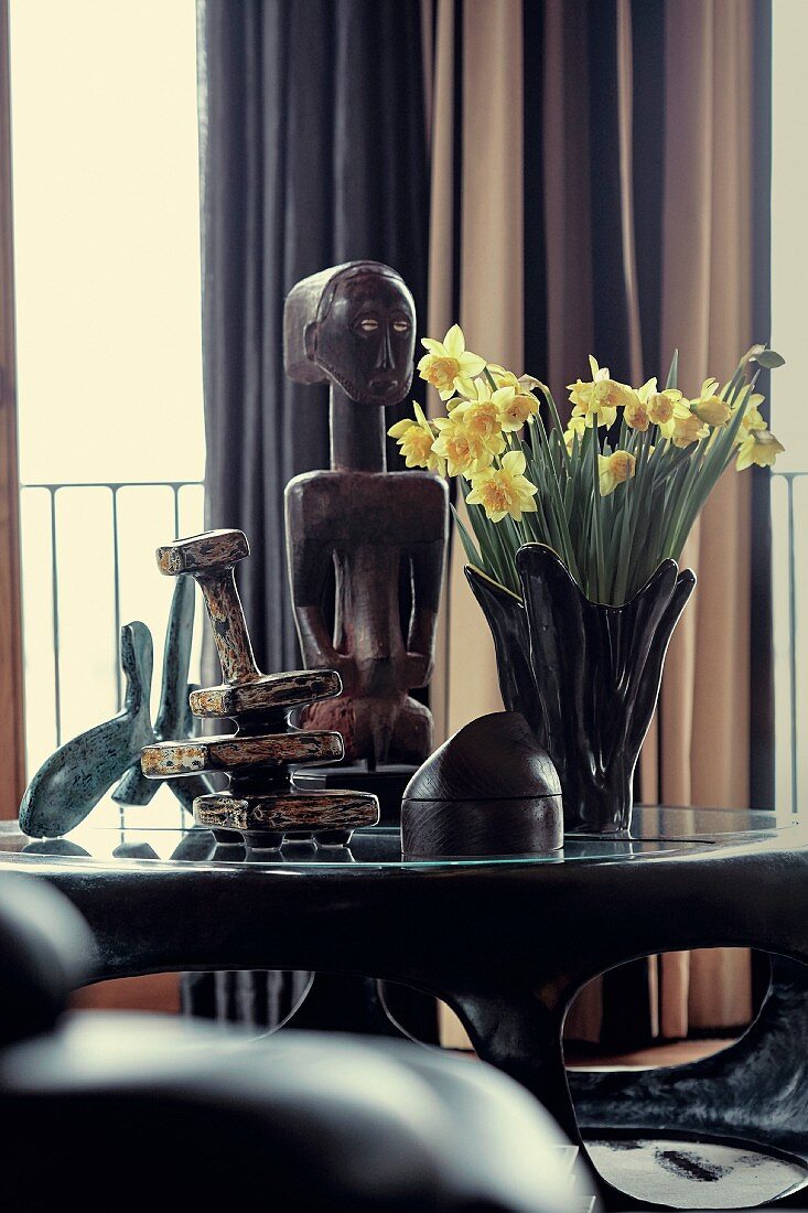 Daffodils and various ethno figures on coffee table