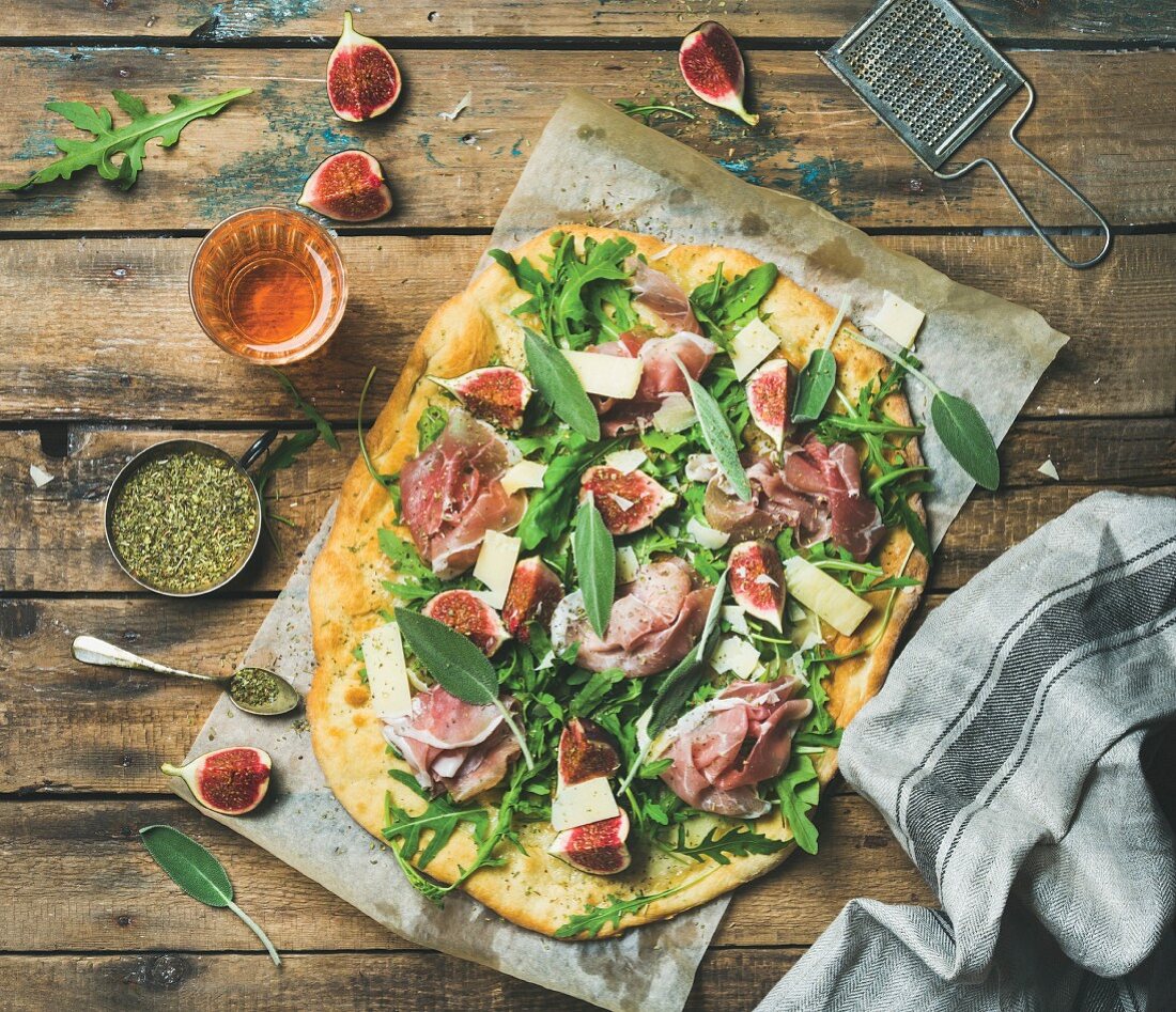Fig, prosciutto, rocket and sage flatbread pizza with a glass of rosé wine