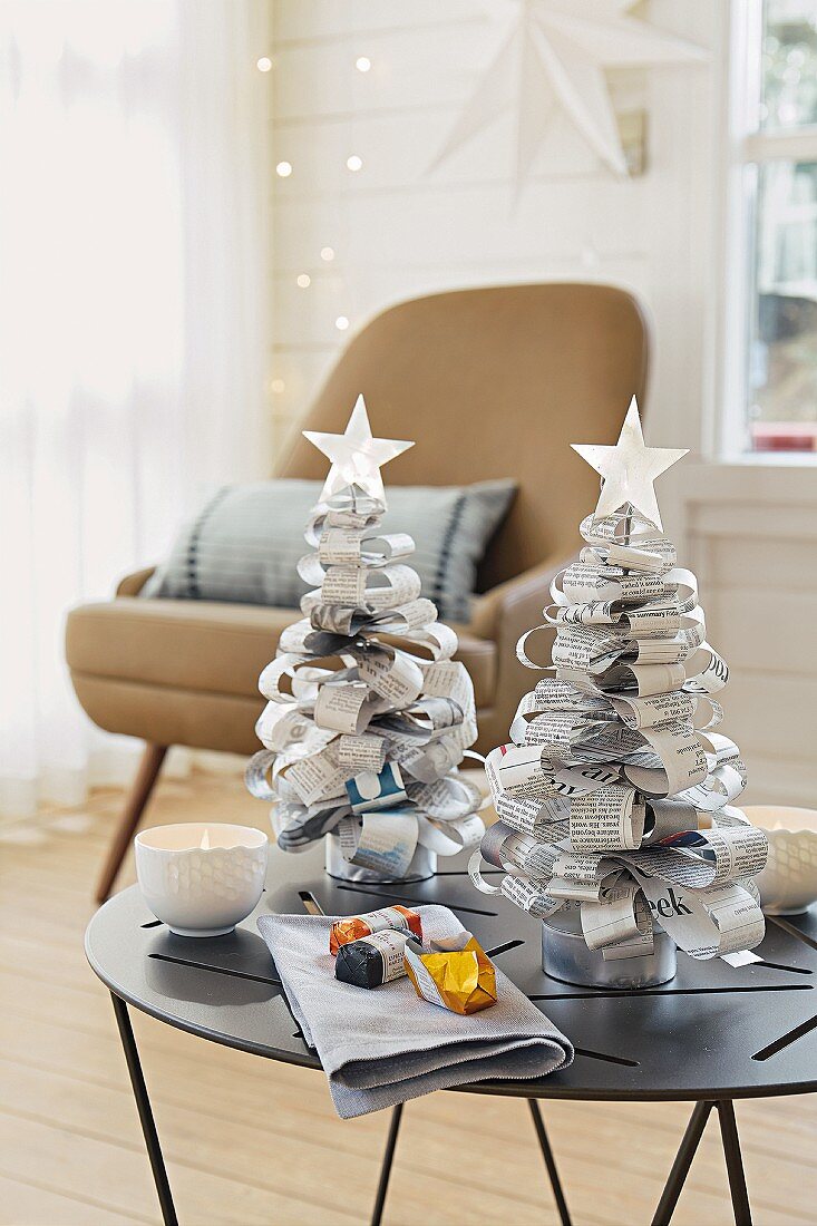 Small Christmas trees made of newspaper on a small table