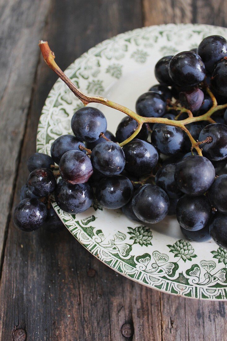 Purple grapes with drops of water on a plate
