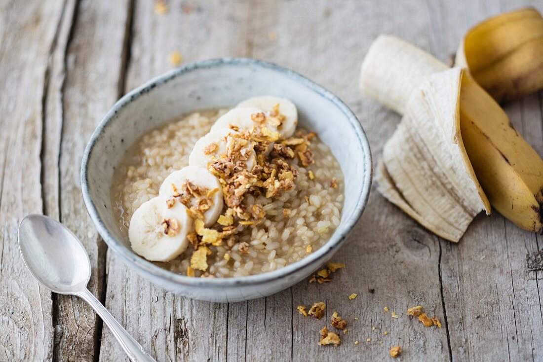 Rice porridge made with lupin and coconut milk with banana and crunchy flakes