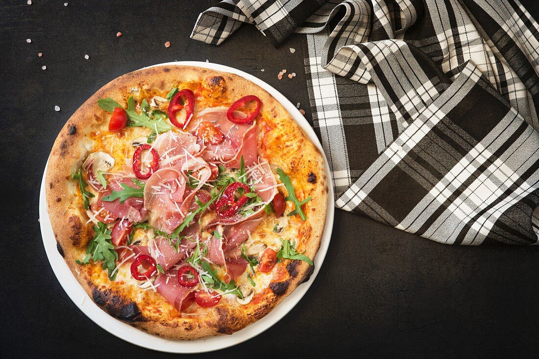 Pizza with ham, cheese and rocket