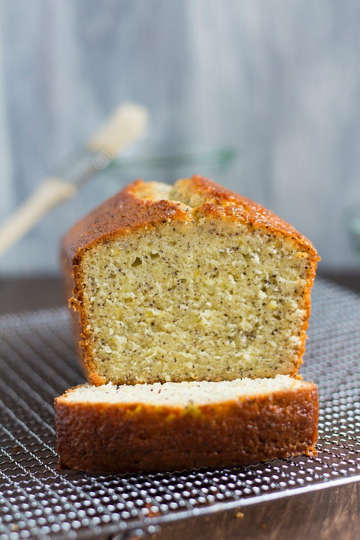 Zitronen-Mohn-Kastenkuchen auf Abkühlgitter (angeschnitten)