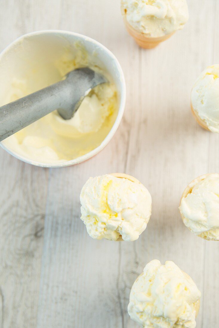 Lemon meringue ice cream in a tub and cones